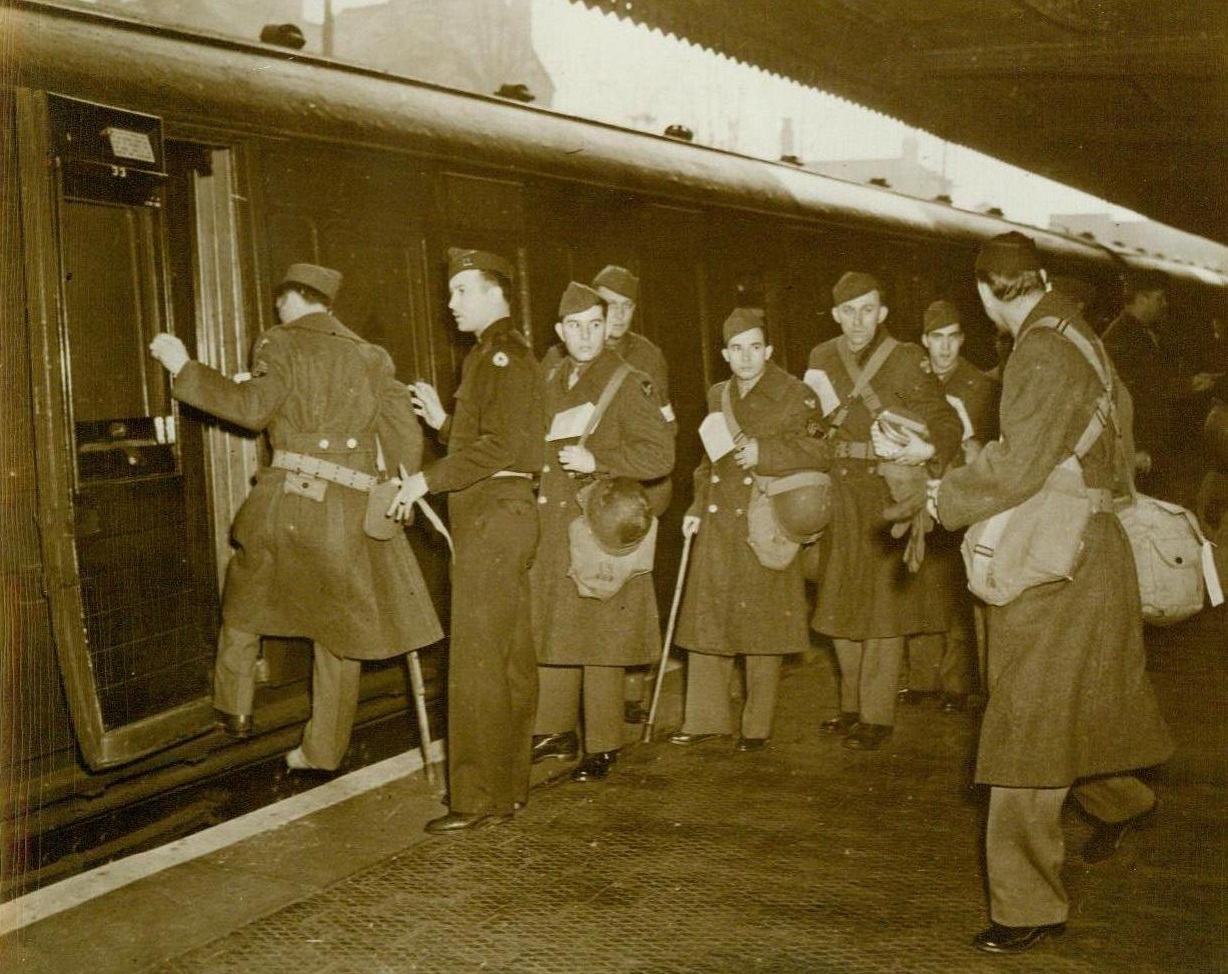 American Wounded Return Home, 5/8/1944. Washington, D.C.- American wounded soldiers board a hospital train in England on their way back ome. They are placed in ward cars according to their type of illness or injury. Many of them will get medical discharges from the Army, while others will be sent to hospitals for further treatment and then returned to active duty. Capt. Capt. V.J. Panvini, of Forest Hills. L.I.N.Y., is seen directing the patients onto the train 5/8/44 Acme;