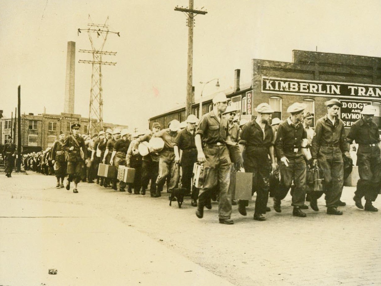 Midwest Sees Nazis March-As Prisoners, 5/26/1944. Hoopeston, Ill. - German war prisoners are marched under guard from the railroad depot in Hoopeston, Ill., to work in vegetable fields and canneries. They will also work in the vicinities of Gibson City, Rossville, and Millford, Ill. They are carefully segregated from civilian laborers. 5/26/44;