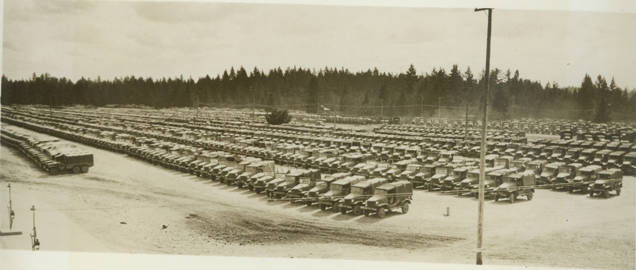 New “Life” for Damaged War Vehicles, 5/2/1944. FORT LEWIS, WASH. – The casualties in vehicles and other equipment in the highly mechanized war, is high. But, shattered steel and machinery is not left on the battlefield to rust and much of it is rebuilt and put back into action—very little is wasted. At the U.S. Army’s Mount Ranier Ordnance Depot, one of the many such Depots in various parts of the country, combat, and service and transport vehicles are repaired, reclaimed or salvaged. Here, the vehicles, collected in the far-flung battle areas of the world, roll in from ports of embarkation on flat cars. They are unloaded and classified and machines which can be repaired to a degree that will restore them to from 95 to 100 per cent as efficient as when new, will be rebuilt and returned overseas. Those which can be repaired but not to as high a degree of efficiency, will be shipped out to training centers, and those beyond repair will be dismantled for salvageable parts. What is left over will be sold for junk and will find its way back into the war effort through scrap. This series of photos, made at the Mount Ranier Ordnance Depot adjacent to Fort Lewis, shows how damaged vehicles are “given new life.” New York Bureau Thousands of reconditioned U.S. Army vehicles, from 95 to 100 per cent as sound as when they were new, are parked in a storage yard at the depot, waiting to be returned to action. Credit: (U.S. Signal Corps Photo from ACME);