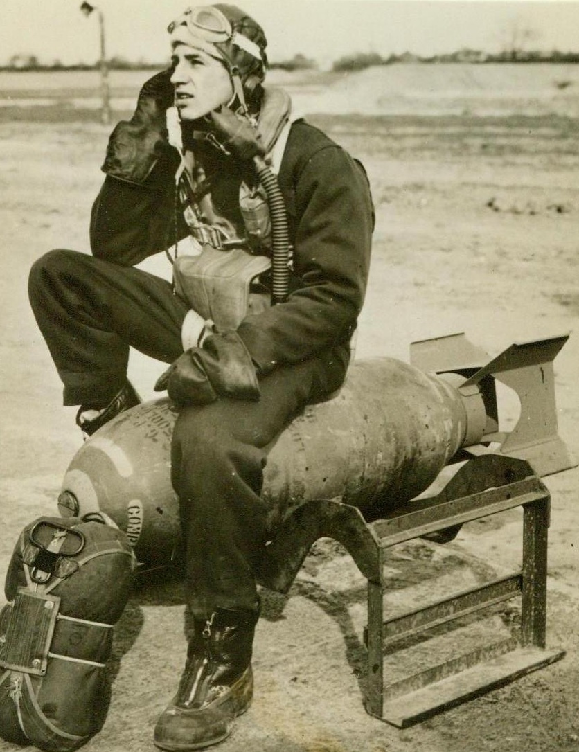 Veteran At Sixteen, 5/12/1944. England – Sgt. De Sales A. Glover, USAAF veteran of six missions over Europe and holder of the Air Medal, sits on a bomb and wonders what age has to do with being a fighting man. Glover, whose home is in Pittsburgh, Pa., is only sixteen years old. He has been grounded while the Army awaits official confirmation of his age before sending him home to civilian status. He enlisted in this man’s Army Oct. 14, 1942 when he was only 14 years old. The young Sgt. was a waist gunner in a Liberation Bomber. 5/12/44 (ACME);