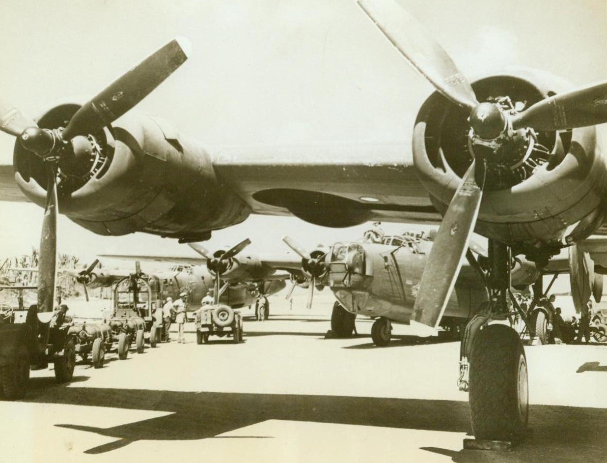 Set To Deliver Downpayment, 5/8/1944. AAF Base in the Marshalls – Bombs destined for delivery as part payment for the sneak bombings of Pearl Harbor and Manila, wait to be loaded in the bomb-bays of these planes by the 7th AAF ground crews at a Marshall Islands airstrip. Aircraft took part in the first joint Army-Navy heavy bomber strike at Guam, April 24. 5/8/44 (USAAF Photo From ACME);