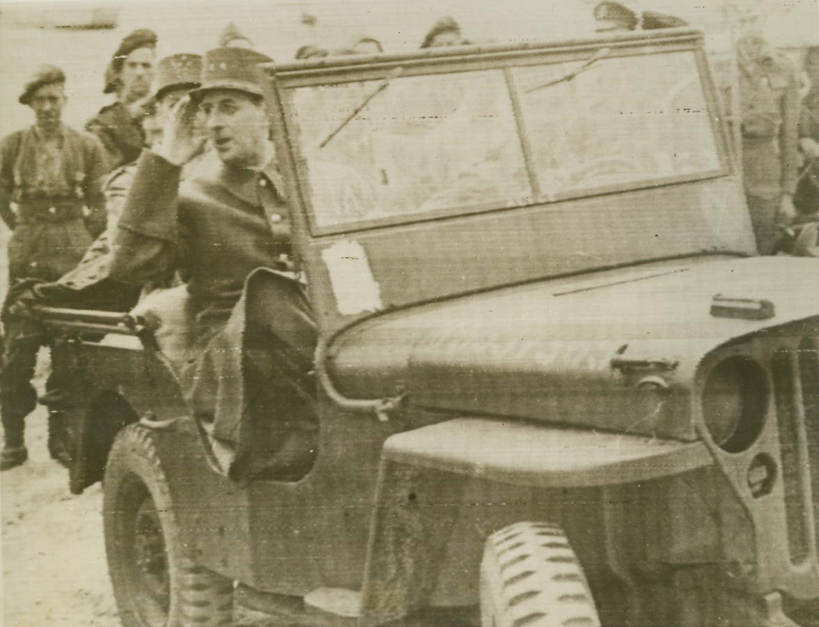 A Frenchman Returns Home, 6/14/1944. FRANCE—Returning to the country that he left almost four years ago, General Charles DeGaulle( saluting), head of the French Committee of National Liberation, rides in a Jeep on tour of inspection of the Allies’ “ Liberation Beachhead” along the Norman coast.  Credit:  British War Office Radiotelephoto ACME;