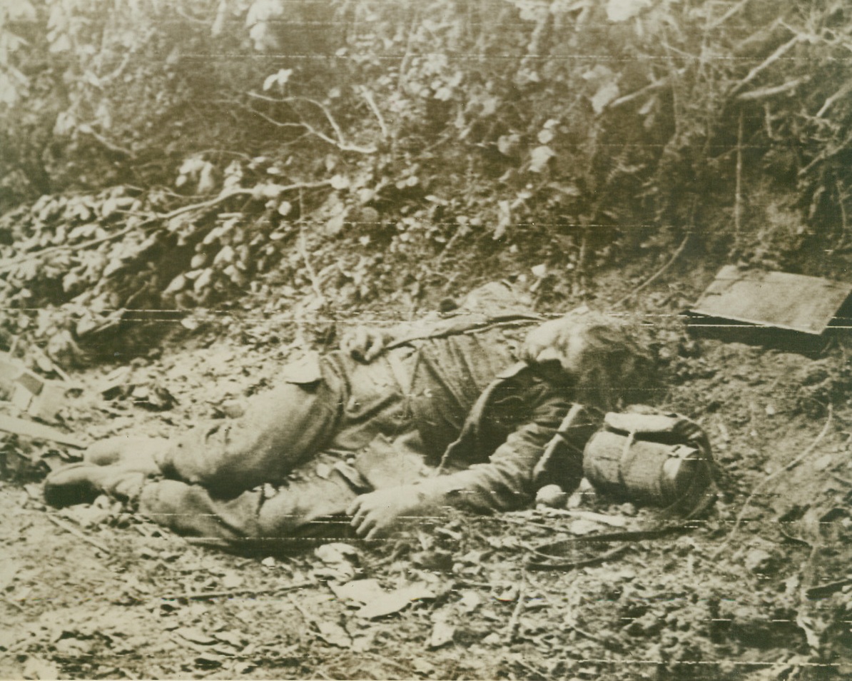 Fallen Nazi, 6/25/1944. SOMEWHERE IN FRANCE – Pushing ahead through the outer defenses of Vital Cherbourg in their rapid advance on the key French Port, American troops came upon this fallen Nazi.  Losing his battle before his fellow Germans admitted defeat in the fight for Cherbourg, the Nazi lies dead in a ditch.Credit:  ACME, photo by Bert Brandt for the War Picture Pool;