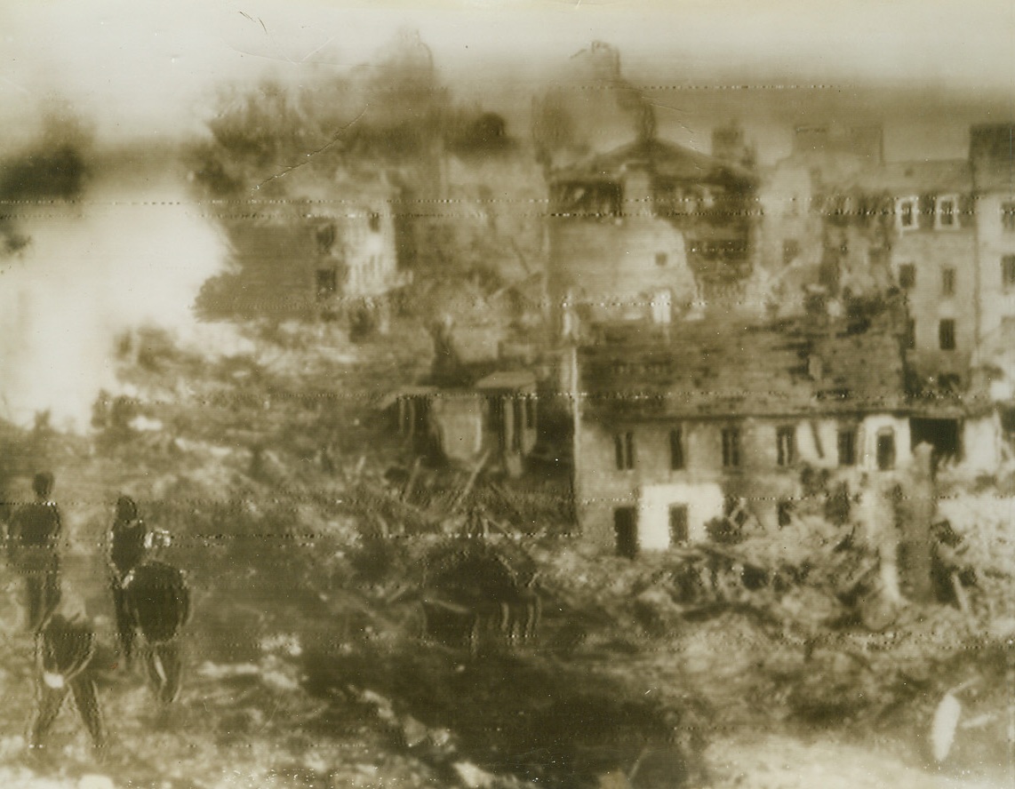 St. Lo Battered By Allies Say Nazis, 6/14/1944. Received in this country through a neutral source, this photo, made by the Germans, is described as showing the French town of St. Lo after heavy bombardment by the Allies. Gutted homes and smoke from still smouldering debris mark this desolate scene. Credit: ACME radiotelephoto.;