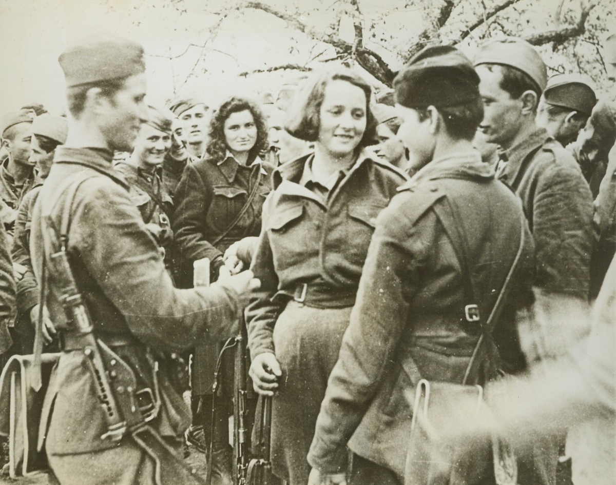 THE SPIRIT OF YUGOSLAVIA, 6/7/1944. YUGOSLAVIA—The second Anti-Fascist Youth Congress of Marshal Tito’s national army of liberation has just concluded and these delegates from the province of Montenegro prepare to make their return journey of about thirty days through enemy territory. It took them thirty days to reach the conference, battling the enemy most of the way. Leader of the party is a young girl, Stana Tomashevitch (center), 21, who has been fighting Nazis for three years, and has been wounded twice. On arrival she was made chairman of the congress. Before the war she was a school teacher and is now a member of the parliament of Montenegro. Credit: Acme;