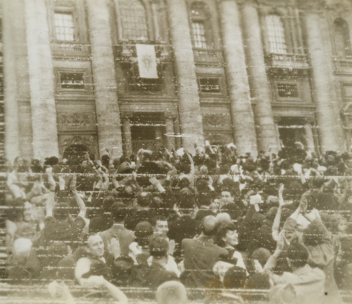 LIBERATED ROMANS GET POPE’S BLESSING, 6/7/1944. ROME—Wildly cheering crowd, celebrating the liberation of Rome from the Germans, gather in St. Peter’s Square to receive Papal blessing. The Pope can be seen on the flag bedecked balcony. Credit: OWI Radiophoto from Acme;