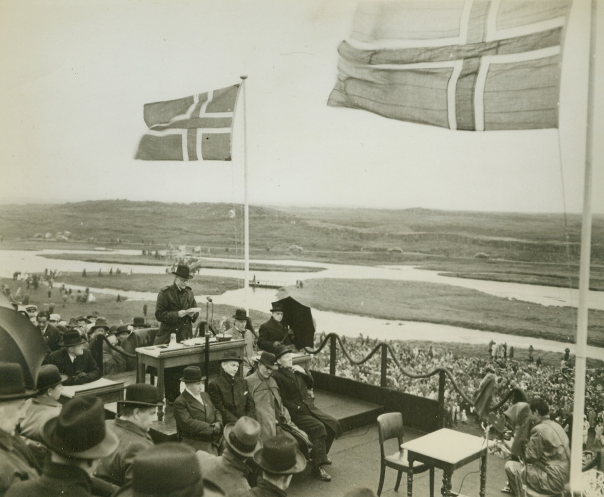 Proclaims Iceland a Republic, 6/27/1944. REYKJAVIK, ICELAND – A tribute to the wisdom of the people of Iceland, was the complete change of the status of their nation to an independent republic, recently. In solemn ceremonies in the open air held on the Parliament Plains (the Thingvellir), Iceland’s thousand-year-old Althing (Parliament) passed the law making the change, after it has been demanded by Icelanders. Here, (standing, left), Gisli Sveinsson (CQ), speaker of the combined houses of Althing, proclaims the Republic formally established and the new constitution effective.Credit: (U.S. Signal Corps Photo from ACME);
