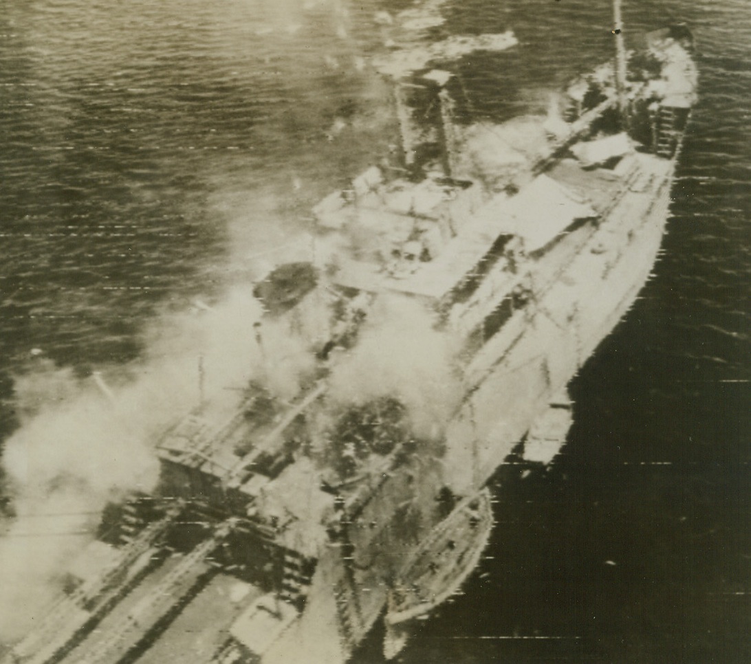 In for the Kill, 6/22/1944. This photo, flashed to the U.S. today by radiotelephoto, was taken from a B-25 Mitchell bomber, as it came in to put the finishing touches on this Jap transport, already smoking heavily and dead in the water. No sign of life can be seen aboard the doomed vessel and anti-aircraft guns are not manned. Note starboard life boat blown from its Davits by a bomb. Lt. Gen. Kenney’s planes caught the ship north of New Guinea. Credit: Fifth Air Forces photo via Army Radiotelephoto from ACME;