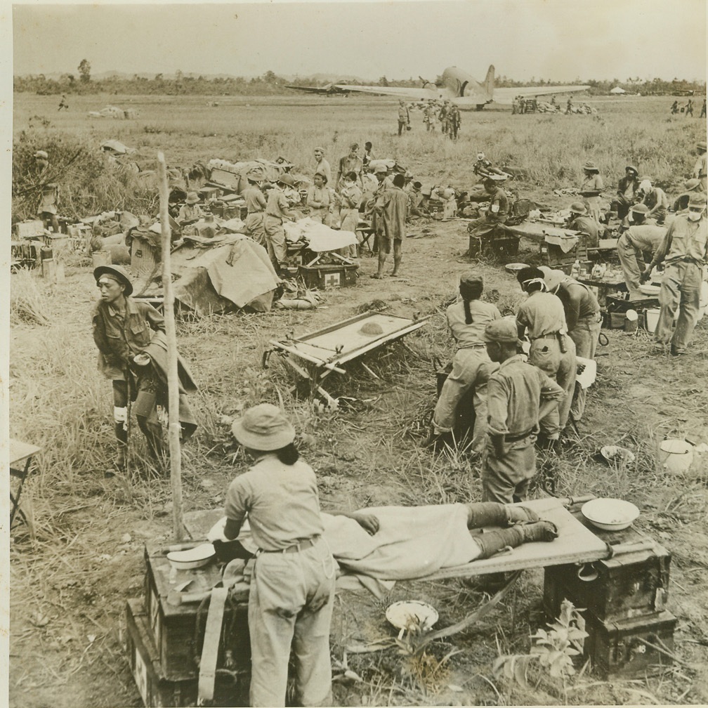Medical Unit at Work on Airfield, 6/17/1944. MYITKYINA, BURMA -- Chinese nurses assist Col. Gordon S. Seagraves in setting up a field hospital for Chinese and American soldiers wounded during a Jap Zero attack on Myitkyina Airdrome. The airfield was taken from the Japs by Merrill's Marauders but Jap snipers and strafing planes returned to cause considerable trouble. Credit (ACME) (WP);
