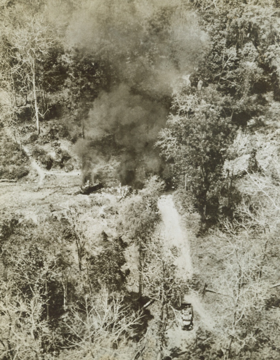 Jap Dead Form Allied Air Beacon, 6/3/1944. Burma – A raiding column, battling the Japs ambushed a truck convoy of Japanese crawling back to their supply depots in Burma. The Allied Column, in order to signal Light Planes to parachute ammunition to them, piled Jap dead in the captured trucks, covered them with oil, and set fire to the convoy. Two of the trucks can be seen in lower foreground and left background. The pyre sent up smoke columns which guided the planes to the spot. A horror story, but war is not for the sensitive. Credit: ACME;