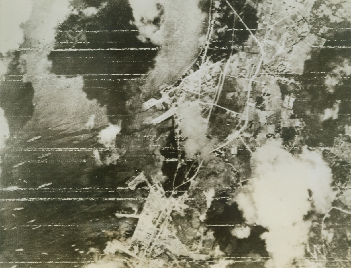 Air Attack Precedes Saipan Landing, 6/16/1944. Saipan, Marianas – This air view taken during the bombing attack preceding landings by US forces shows the seaplane base North of Flores Point.  On the plane ramp are four 4-engined flying boats of the Mavis type.  The harbor is cotted with warships, transports, and a sub.  Heavy fighting continues in the Saipan area, and US forces have captured Agingan Point and are now battling for the town of Charan-Kanoa. Credit line (Signal Corps Radio telephoto from ACME);