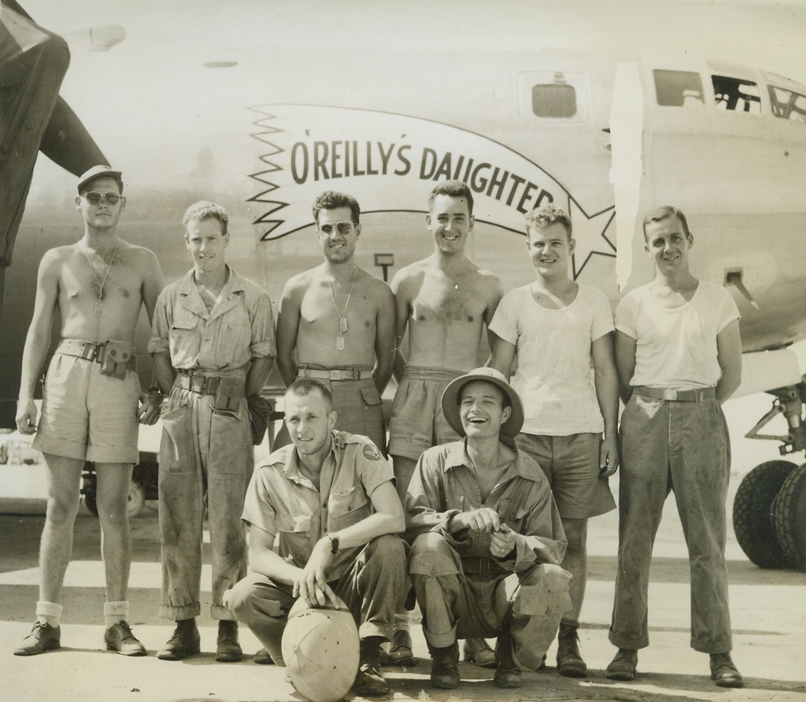 “O-Reilly’s Daughter: Raring to Go, 6/18/1944. China – The crew of “O’Reilly’s Daughter”, named after the song so popular with Air Corpsmen, is mighty proud of the success of the raid staged on Japan by B-29 superfortresses in their maiden operational flight.  Winging over the Japanese mainland on June 15, these gigantic planes of the 20th bomber command had as their main target Yawata, important steel center.  They also attacked Kokura and Moji.  Left to right, standing; Sgt. William beckham, radar, Albany, Ga.; Sgt. Rollin Heffernan, gunner, Apollo, Pa.; Sgt. W. Alpaugh, radio, Rockford, Ohio; Sgt. E. Brandaze, gunner, Pittsfield, Mass.; Sgt. Grandville Adams, gunner, Messick, Va.; and Sgt. J. Meechan, gunner, Cleveland, Ohio.  Kneeling, left to right: Capt. E. Winkler, co-pilot, Ogden, Utah, and Capt. Louis Wedel, bombardier, Hereford, Texas. Credit (ACME photo by Frank Cancellare, War Pool correspondent);