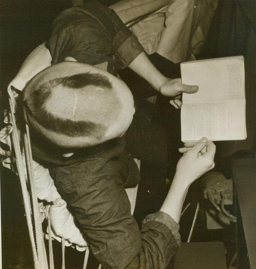 Shorn of His Locks, 6/19/1944. Somewhere in the Pacific – Mrs. Ducy would never recognize her son Seaman 2/c Bob Ducy, Hartford City, Ind., with all his brunette locks shorn into one forlorn “V”.  Seaman Ducy is aboard an aircraft carrier loaded with supplies and equipment for a naval station somewhere in the Pacific. Credit (ACME photo by Stanley Troutman, War pool correspondent);