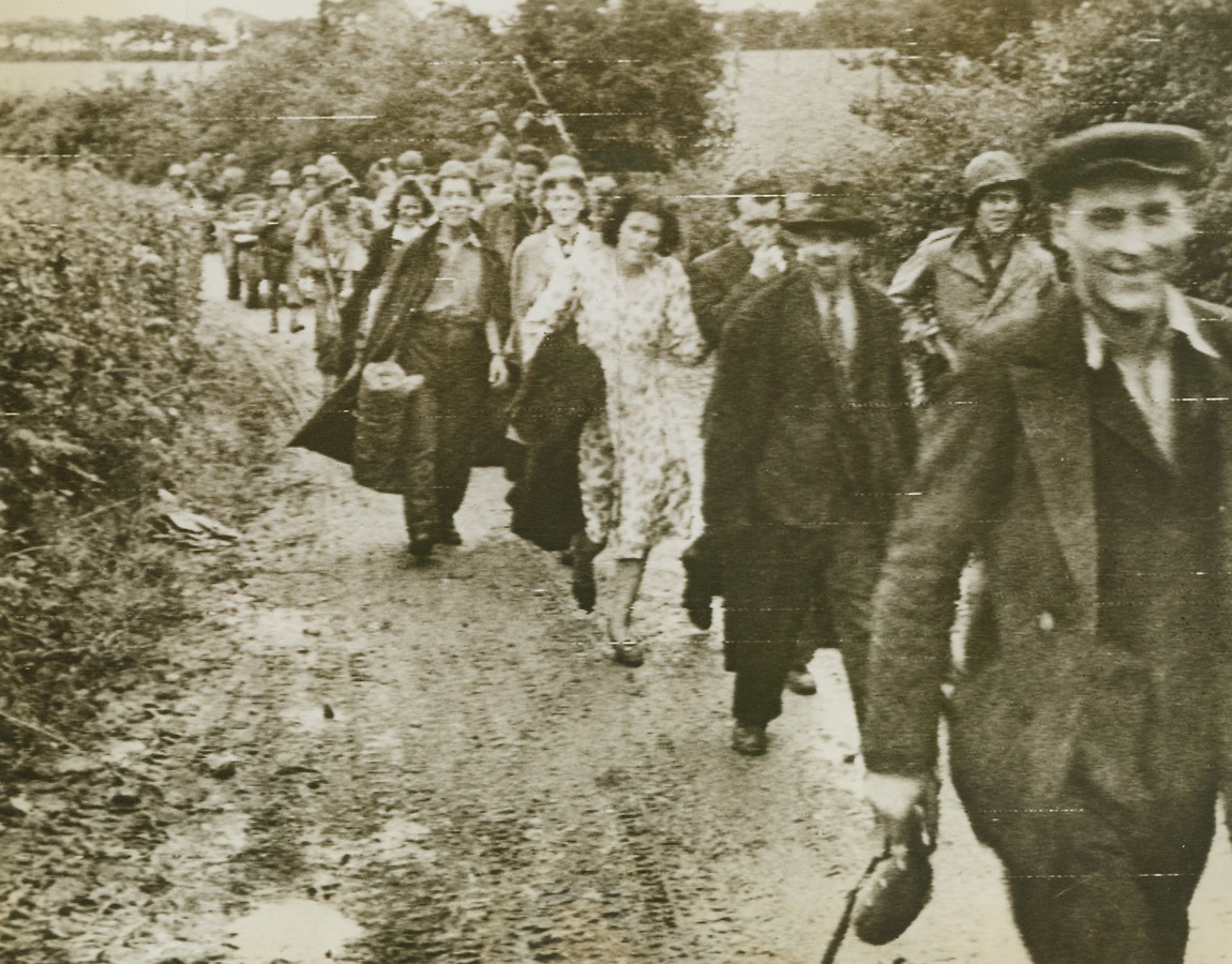 Bound for Home, 6/29/1944. Cherbourg, France—Homeward bound, smiling French civilians trek back to the ruins of their houses in liberated Cherbourg after the vital city had been occupied by American troops. Although each fears that his home may not be there when he reaches it, the Frenchmen still smile, glad that they no longer have to worry about war being fought on their doorsteps. Credit: ACME photo via Army radiotelephoto.;