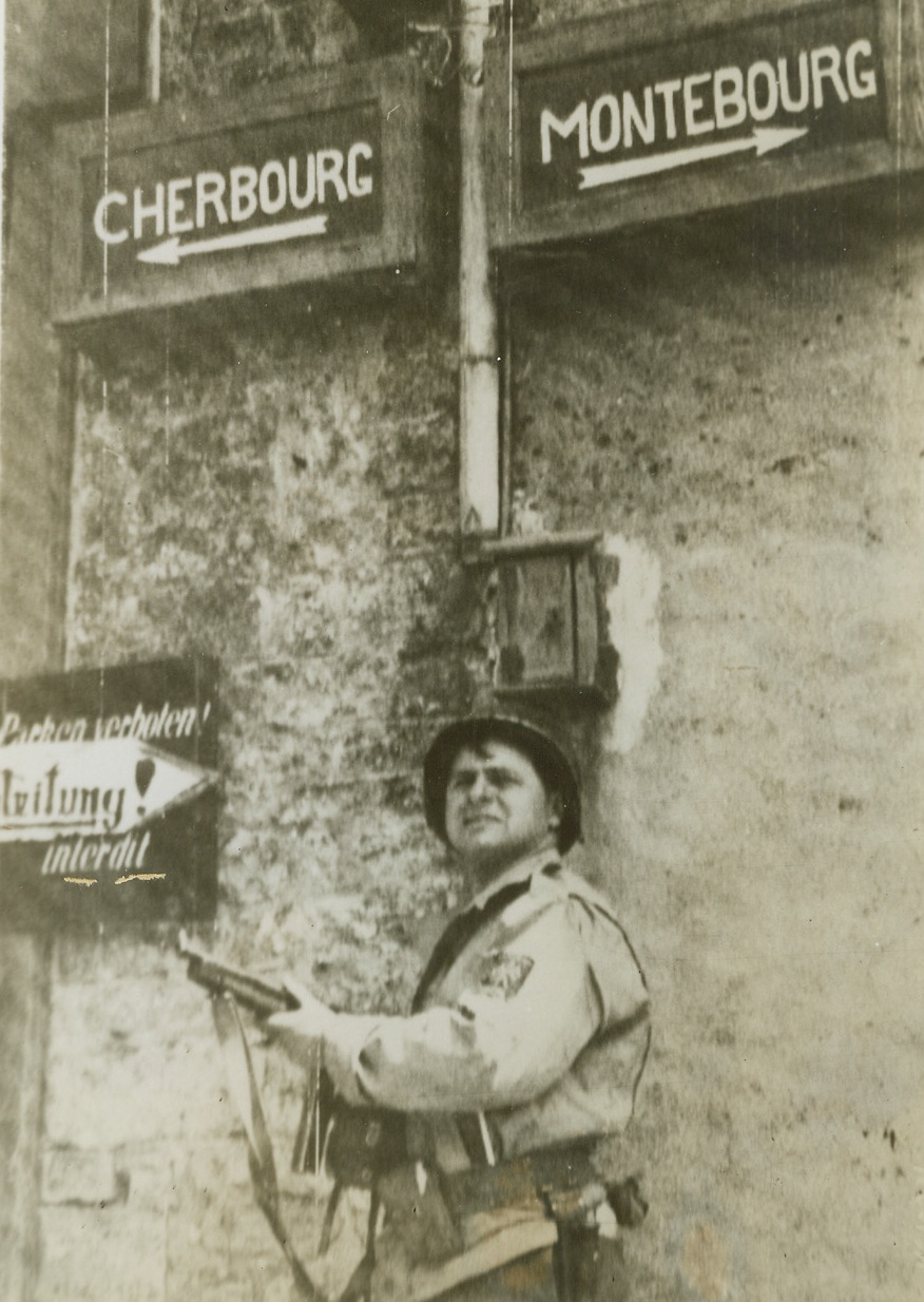 Headed For Cherbourg, 6/22/1944. France - Armed with a Tommy Gun, Signal Corps photographer Cpl. David Halberg, Cleveland, O., looks forward to the next town on the time table of the Allied Armies of Liberation - Cherbourg. Halberg was the first man to enter the town of Montebourg. Credit: Army Radiotelephoto from ACME;