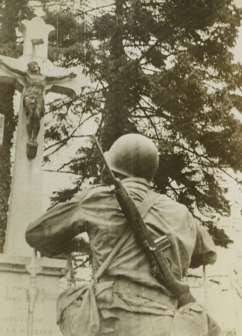 Liberator Pauses for Prayer, 6/14/1944. France - An American soldier pauses in the battle for the liberation of the people of France and the whole of Nazi-enslaved Europe for a brief moment of meditation at a way-side shrine set deep in a wooded grove. Just a moment’s pause and then this soldier will once more move on with the advancing Allied troops cracking Hitler’s Fortress wide open. Credit: Signal Corps Radiotelephoto from ACME;