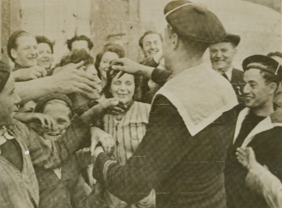 French Sailors “Invade” Homeland, 6/14/1944. France - In Port-En-Bessin, first port captured by the Allies in Normandy, is visited by French sailors who hopped off their ships to shake hands with their fellow countrymen. This was the first time in four years that some had been on their own native soil. Above civilians vie with each other to shake the sailors’ hands. Credit: British War Office photo via Signal Corps Radiotelephoto from ACME;