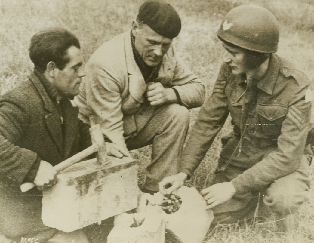 French Underground Secret, 6/16/1944. France – Doisy Marcel, of Coieville, Normandy explains to a British sergeant how ammunition stolen from the Nazis was hidden in paving stones to help the resistance movement. Marcel is a contractor when he is not hunting Nazis 6/16/44 Credit (British War Office Photo Via Signal Corps Radiotelephoto From ACME);