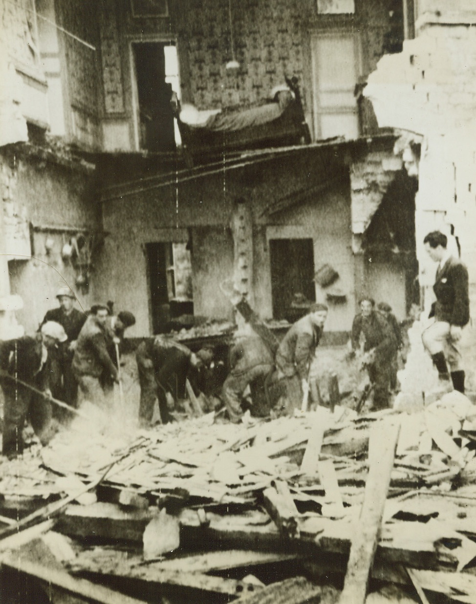 Cherbourg Citizens Dig Out, 6/29/1944. France – Returning to their homes after the capture of Cherbourg by the Allies, citizens of the French city start the important task of digging out the debris to start reconstruction operations. The scene of the most bitter fighting on the Normandy Peninsula, shattered homes are evidence of the terrific artillery fire from both the Allies and the Nazis the city was subjected to. Credit: Signal Corps Radiotelephoto from ACME;