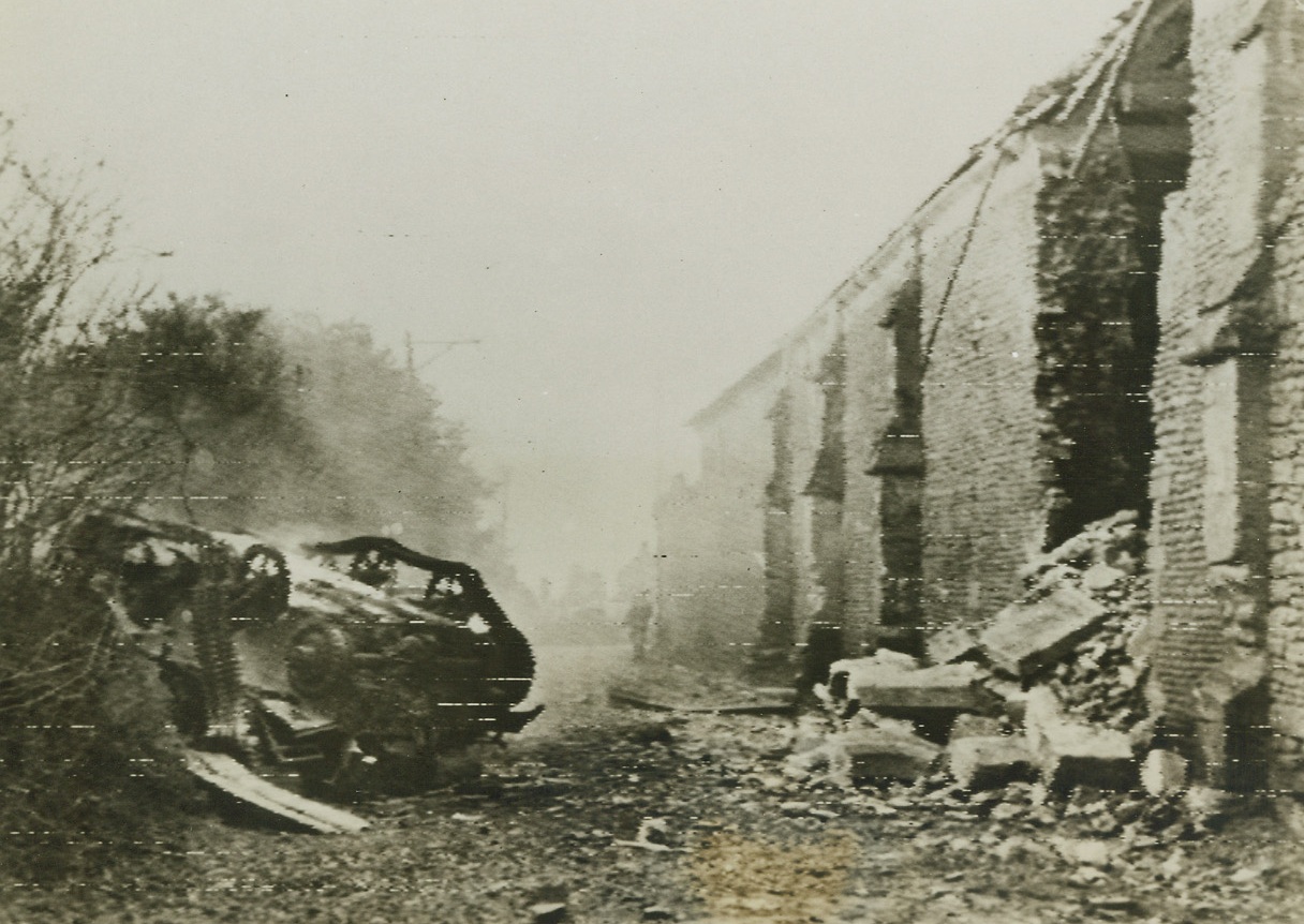 Enemy Mines Take Toll, 6/13/1944. Washington, D.C. – Even though the enemy may have been driven from this sector of the invasion beachhead, all is not safe. Overturned Bren Carrier (left) moving on a French road hit a mine and was flipped over as easily as one turns over a matchstick. Credit: Official Canadian photo from London via Signal Corps Radio-telephoto from ACME;