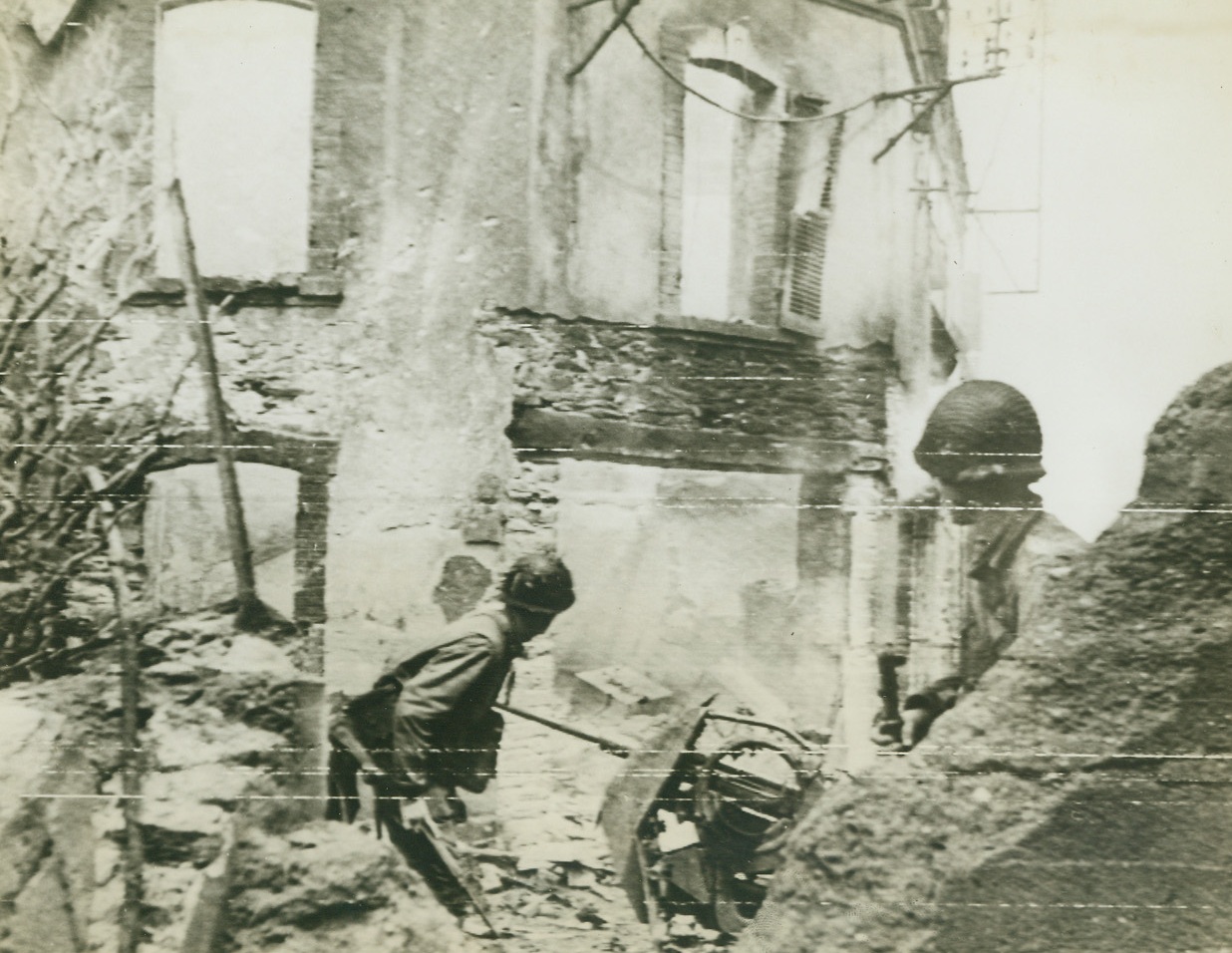 Sniper Hunt, 6/27/1944. Cherbourg, France – Amid the ruins of Cherbourg, two American soldiers peer at a window from which a German sniper had been shooting at U.S. troops. Photo, flashed to the U.S. by radiotelephoto today, was taken during the hand-to-hand fighting in the streets of the important channel port after the Nazi commanders had surrendered. Credit: ACME photo by Bert Brandt for War Picture Pool via Army Radiotelephoto;
