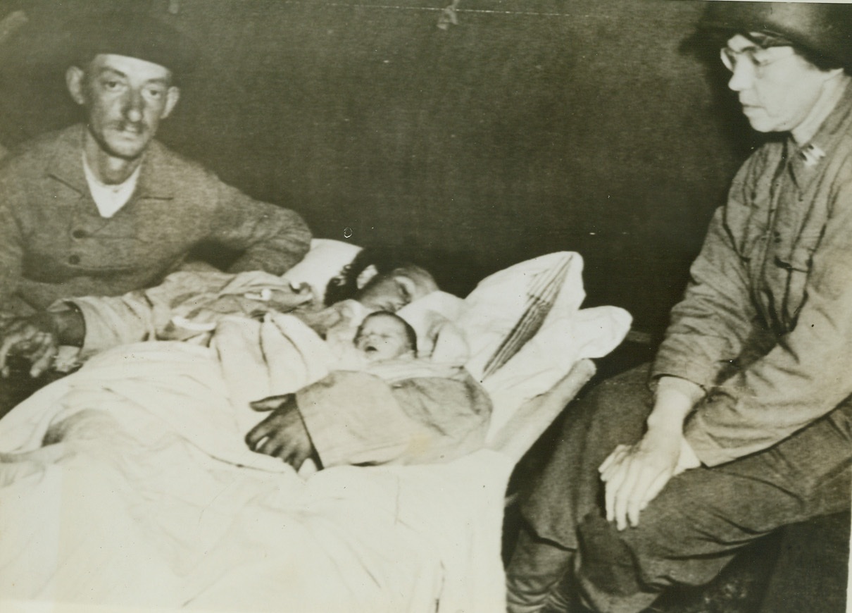 First Baby Born In U.S. Beachhead Hospital, 6/28/1944. France – Believed to be the first French baby to be born in a U.S. hospital in France, Bieni-Aime Cousnnfeory is shown here with its mother and father. At the right, is Capt. Kathryn Helm, of Cleveland, Ohio, Chief Nurse at the hospital on the Cherbourg Peninsula. Credit: Army Radiotelephoto from ACME;