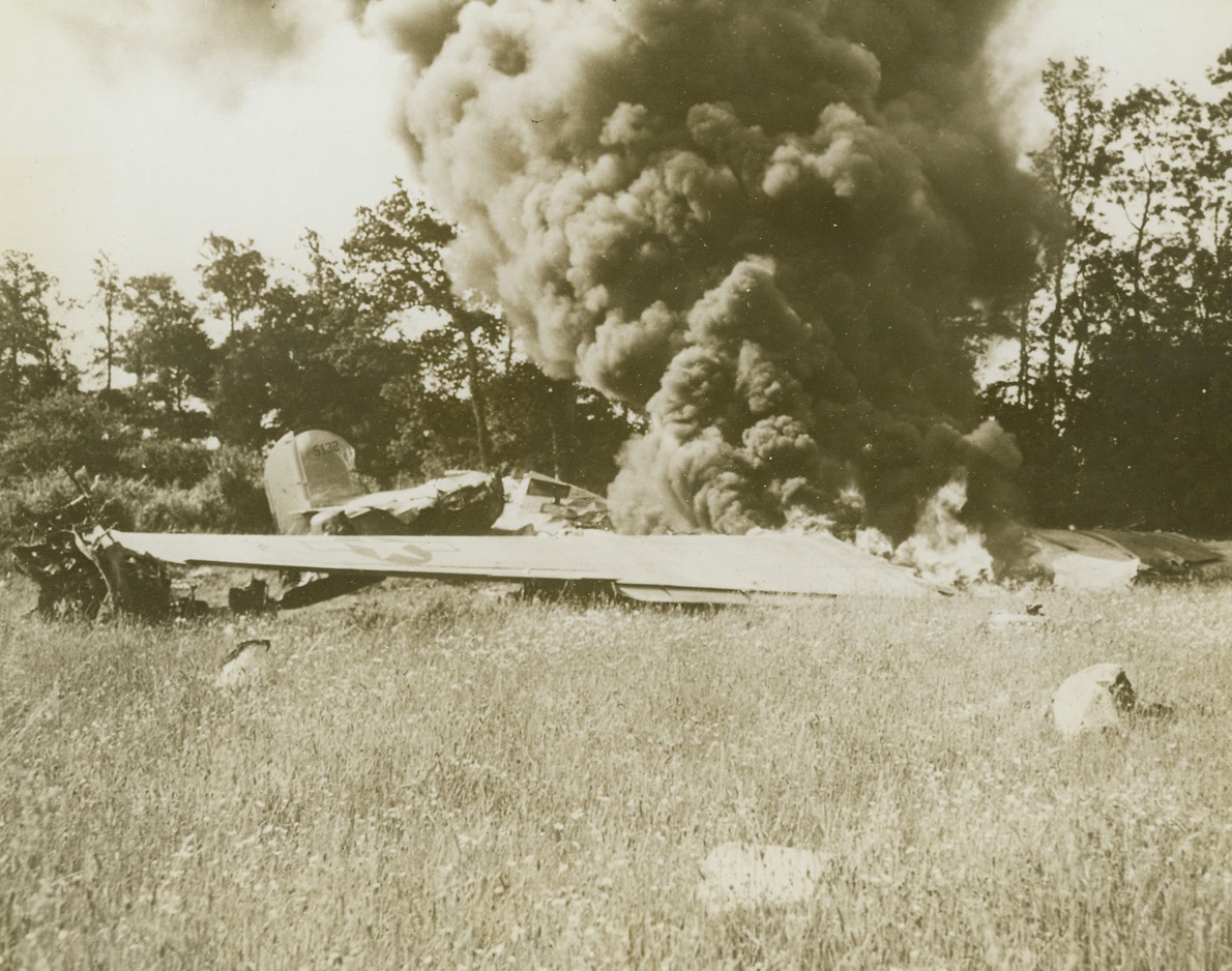 Downed Liberator, 6/23/1944. France – Smoke billows skyward from the wreckage of this Liberator which crashed in a field in France after being disabled while on a bombing mission. Thousands of planes have been forming an aerial umbrella for the Allied soldiers bitterly engaged in battle with the Nazis in France. Credit: US Army photo from ACME;