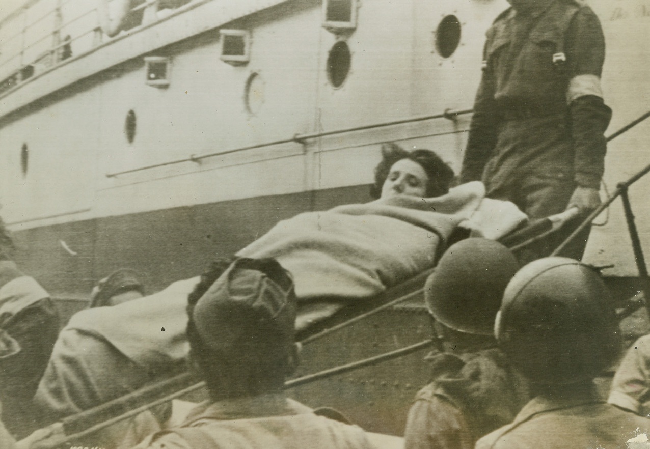 Suspected Quisling, 6/16/1944. This French woman, suspected of being a sniper against the Allied forces in France, arrives in England and is being evacuated to a Prisoner of War hospital. She was wounded in the hand and body. Credit: ACME photo via Army Radiotelephoto;