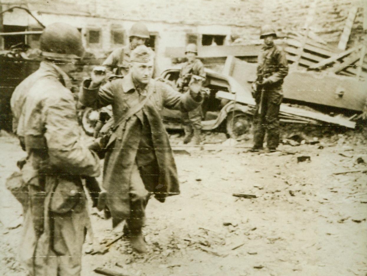 Vanquished Cherbourg Defender, 6/28/1944. Cherbourg - His hands upraised and a definitely unhappy look on his face, a German prisoner emerges from an underground fortress in Cherbourg. The enemy's resistance though stubborn could not last long in the key channel port once the Allies got started 6/28/44 (ACME);