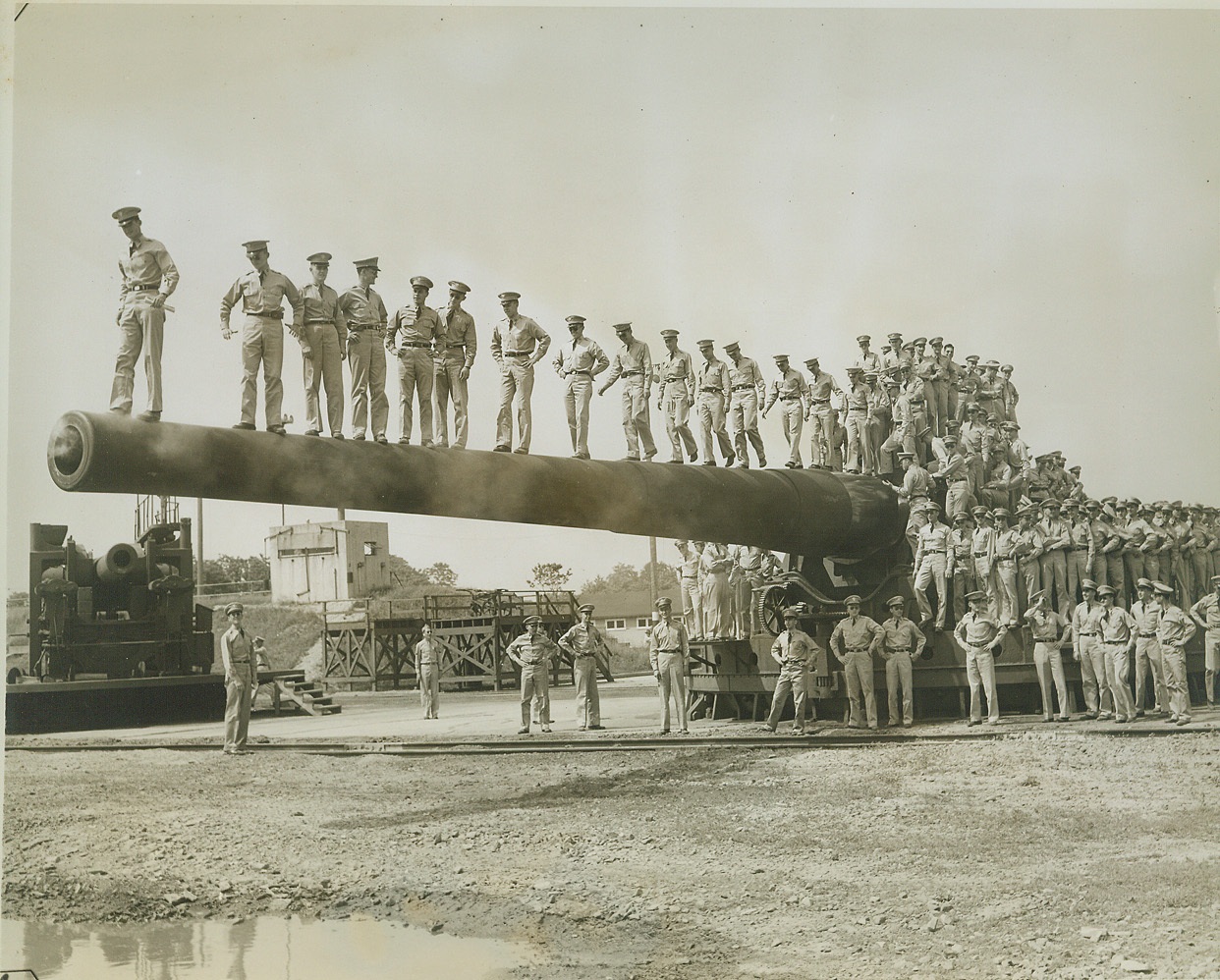 Mighty Diving Board, 6/1/1944. ABERDEEN, MD. – In the 21st annual training visit to the Aberdeen, Md., Proving Grounds, 303 members of the graduating class of the West Point Military Academy were introduced to the might of American ordnance. They saw everything from the little carbine to the powerful 16-inch gun. Here they pose with one of the 16-inchers which they later saw in action. Credit: (ACME);