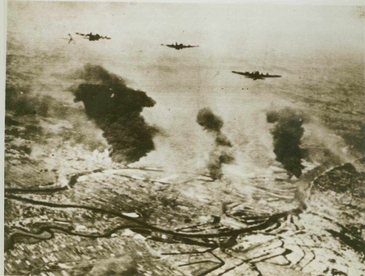 Hamburg Gets It Again, 6/25/1944. HAMBURG, GERMANY – Great clouds of oily black smoke drift skyward from the burning oil refineries at Hamburg. Three attacking Flying Fortresses of the 8th Air Force, which staged the raid, wing over the flaming plant. Credit: (Signal Corps Radiotelephoto-ACME);