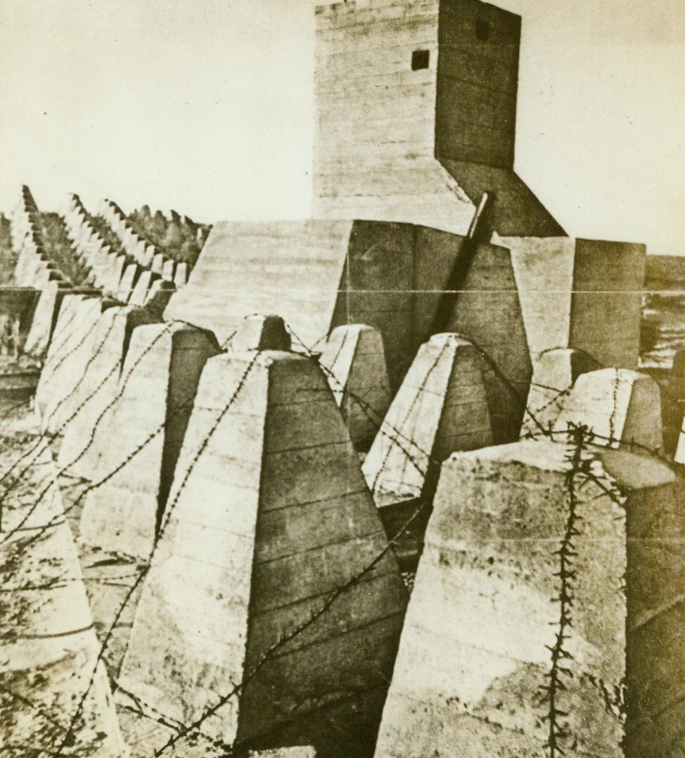 What Invasion Troops Must Still Face, 6/8/1944. This photograph which arrived in the United States from a neutral source, shows lines of reinforced concrete anti-tank obstacles on the Atlantic Wall. Although spearhead invasion troops have established beachheads on the French coast and are now fighting inland, they will not face the obstacles created by the Atlantic wall until they have penetrated one hundred miles inland. At that point, according to the Nazis, the real invasion defenses start. 6/8/44 (ACME);