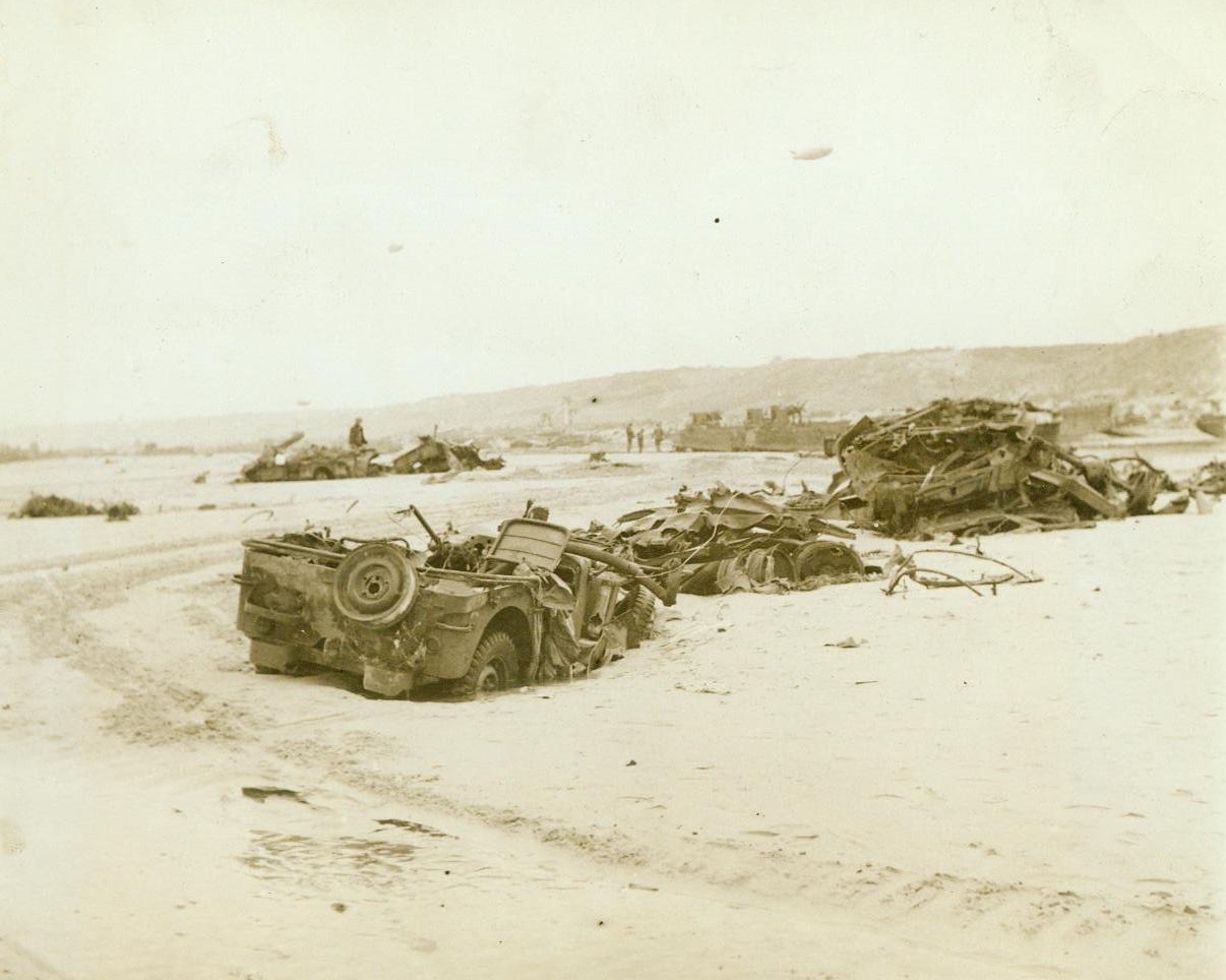 Why War Bonds Are A Must, 6/14/1944. France – In graphic detail these wrecked armored vehicles tell the story of the fierceness of the battle to establish beachheads in France. No plea is necessary for the sale of war bonds. The need to keep the Allied Armies fighting for the liberation of Nazi-enslaved Europe are reinforced is ever present. American soldiers, joined in this historic battle, must be given the best possible equipment. The way to get it to them is to buy more war bonds 6/14/44 (ACME Photo By Bert Brandt, War Pool Correspondent);