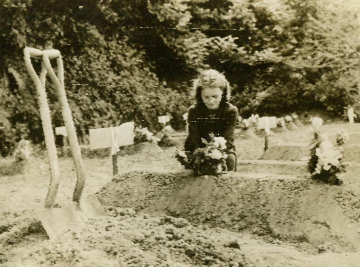 To The Memory Of A Hero, 6/12/1944. Killed far away from home, an American Airborne soldier was buried in the famous poppy fields of France, and a little French girl places flowers on his freshly-dug grave. The French look upon the Americans and their brother Allies as heroes who brought liberation to France when they landed on its shores 6/12/44 (Army Radiotelephoto From ACME);