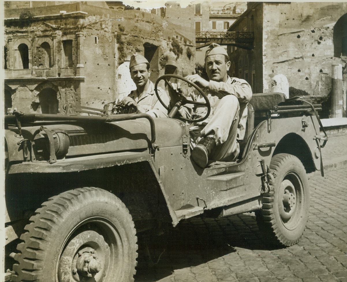 ACME Photographers in Rome, 7/5/1944. Rome, Italy – At the front lines with Allied fighting men, Charles Seawood (left) and Sherman Montrose, ACME Newspictures War Correspondents, were under fire and suffered the privations all fighting men must when engaging the enemy. Away from the scenes of battle, the two ace photographers tour the streets of Rome getting their fill of the sights. Ever the cameraman, the ACME boys, nevertheless, lug their equipment with them.  Credit (ACME Photo by Sherman Montrose, War Pool Correspondent);