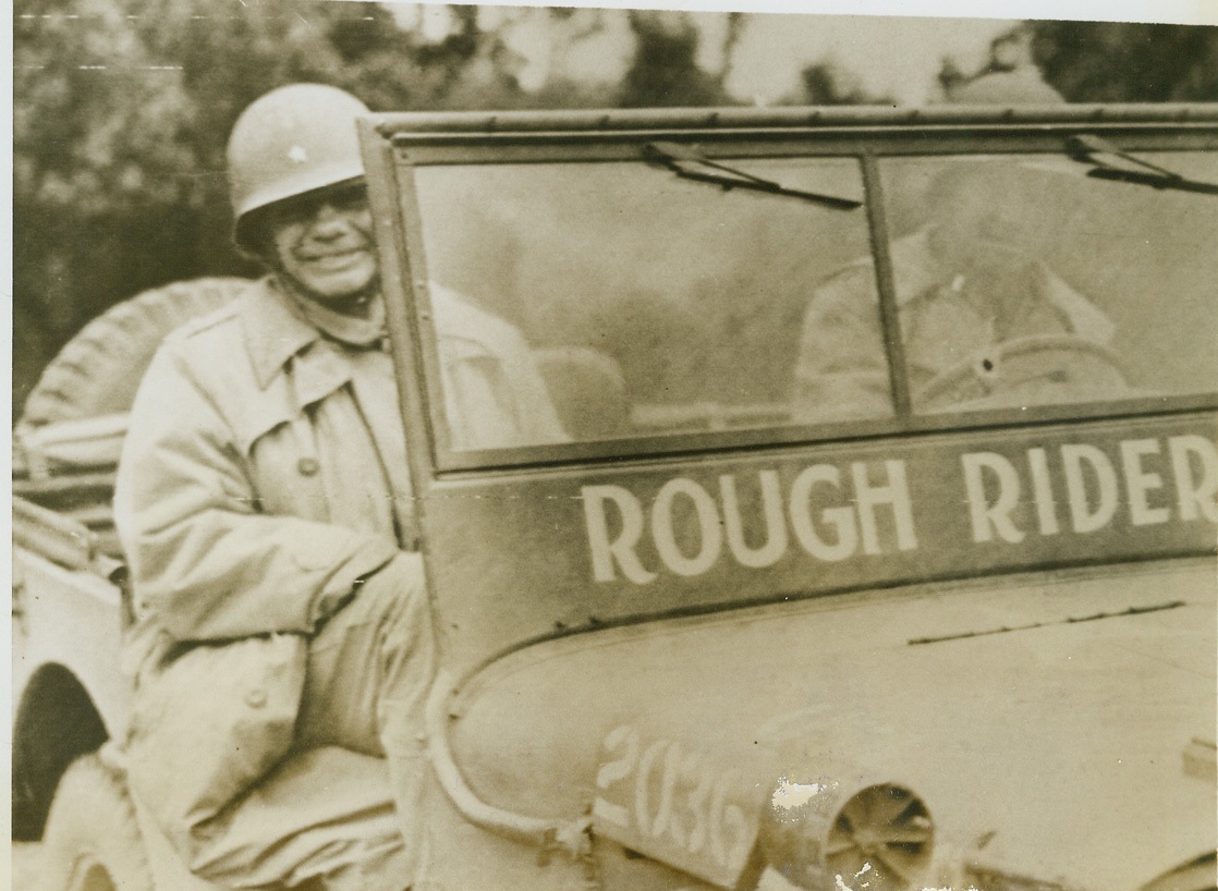 BRIG. GEN. ROOSEVELT ON HIS LAST RIDE, 7/15/1944. FRANCE – This last picture of the late Brig. Gen. Theodore Roosevelt shows the soldier-statesman on his last inspection trip riding his jeep “Rough Rider”. Photo was taken at an Infantry post in France. The infectious smile of the late General is an indication of why he was worshipped by the men he commanded. Credit: Signal Corps photo via OWI Radiophoto from ACME;