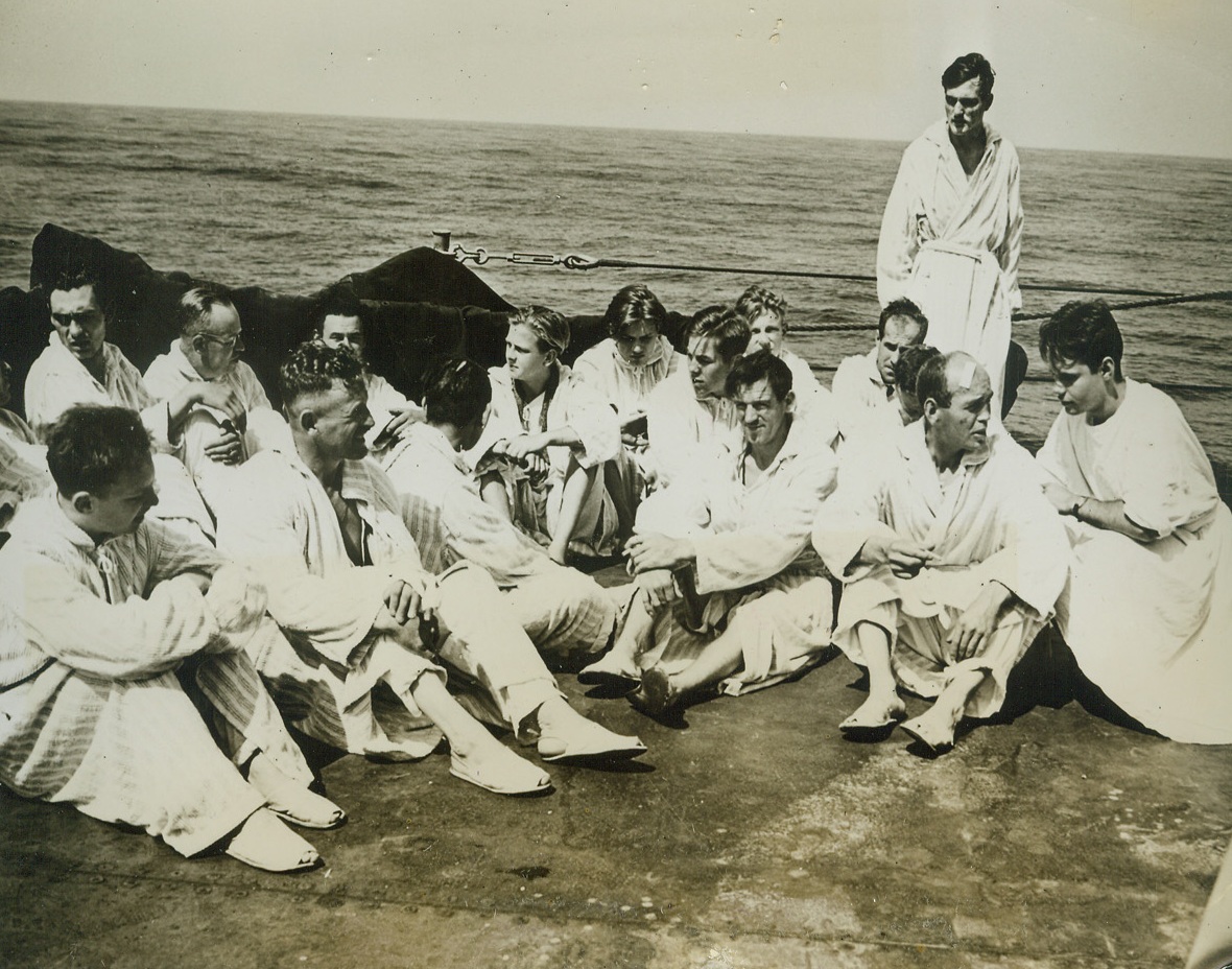 German Prisoners Head for U.S., 7/26/1944. AT SEA -- Headed for the United States, wounded and ailing German prisoners follow doctor's orders and get plenty of fresh air and sunshine as they lounge on the open deck of a Coast Guard-manned transport. They are attired in robes and slippers provided for them. A Coast Guardsman, at right, chats with an English-speaking prisoner. Credit (Coast Guard Photo from ACME);