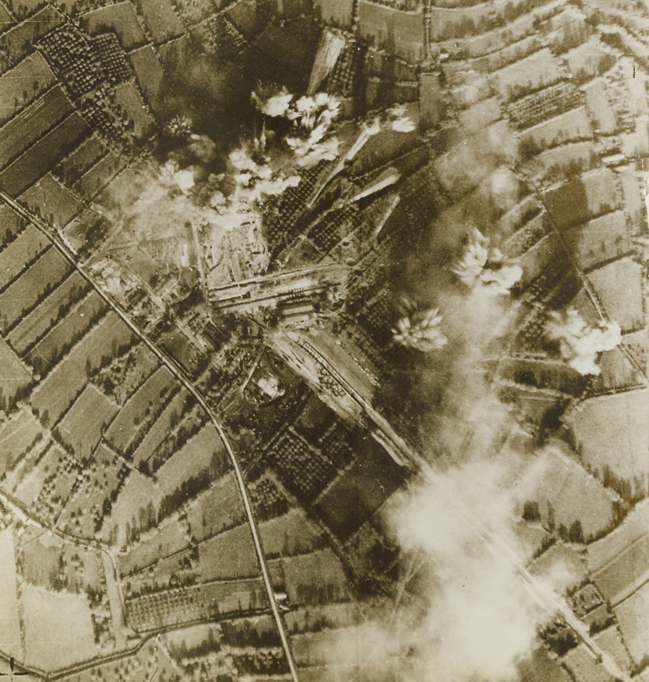 BLAST ROBOT BASES, 7/7/1944. Kept secret for security reasons, this photo reveals that the U.S. Army 9th Air Force Bomber and Fighter-bomber planes have been attacking for some time the sites and launching platforms of the Nazi pilotless planes—the alleged secret weapon of the enemy. Plainly visible bomb bursts concentrated in the target area indicate that this site was put out of commission temporarily at least. Credit: USAAF photo from Acme;