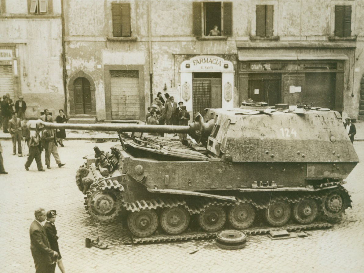 “FERDINAND” GETS LEFT, 7/4/1944. SORIANO, ITALY—Meet “Ferdinand,” the 70-ton, 88mm. self-propelled gun which the Nazis abandoned when they fled Soriano in the face of the British 8th Army attack. German forces usually blow up any vehicles or equipment which they have to leave behind, but evidently they were in too much of a hurry to take care of Ferdinand. Credit: British official photo from Acme;