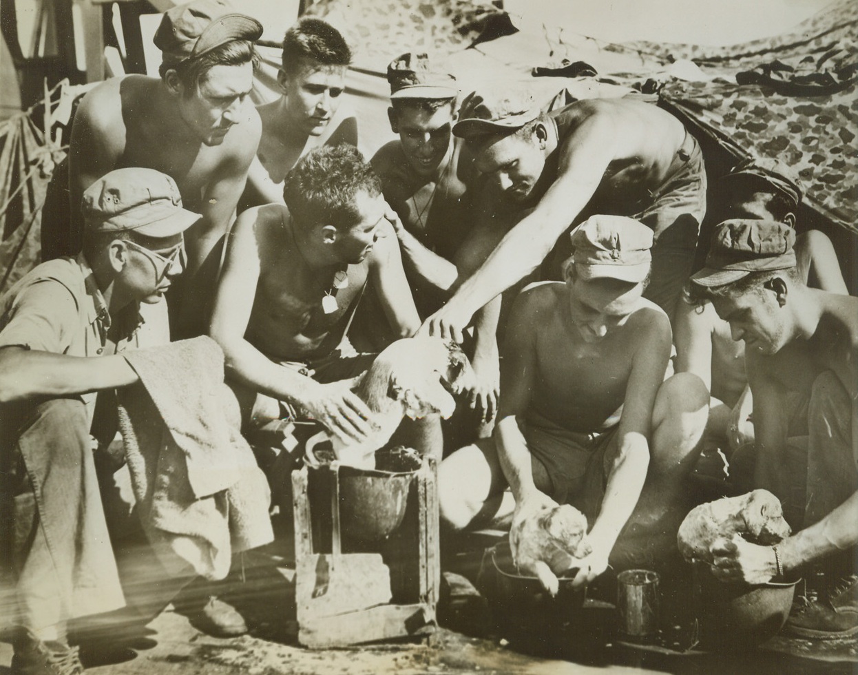 Those Versatile Helmets!, 7/27/1944. At Sea – Here is a new use for those handy GI “toppers” – a scrub tub for pups! U.S. Marines, headed for a landing on Guam, primp their pets for the occasion, receiving advice – and some help – from their buddies.Credit: U.S. Marine Corps photo from ACME;