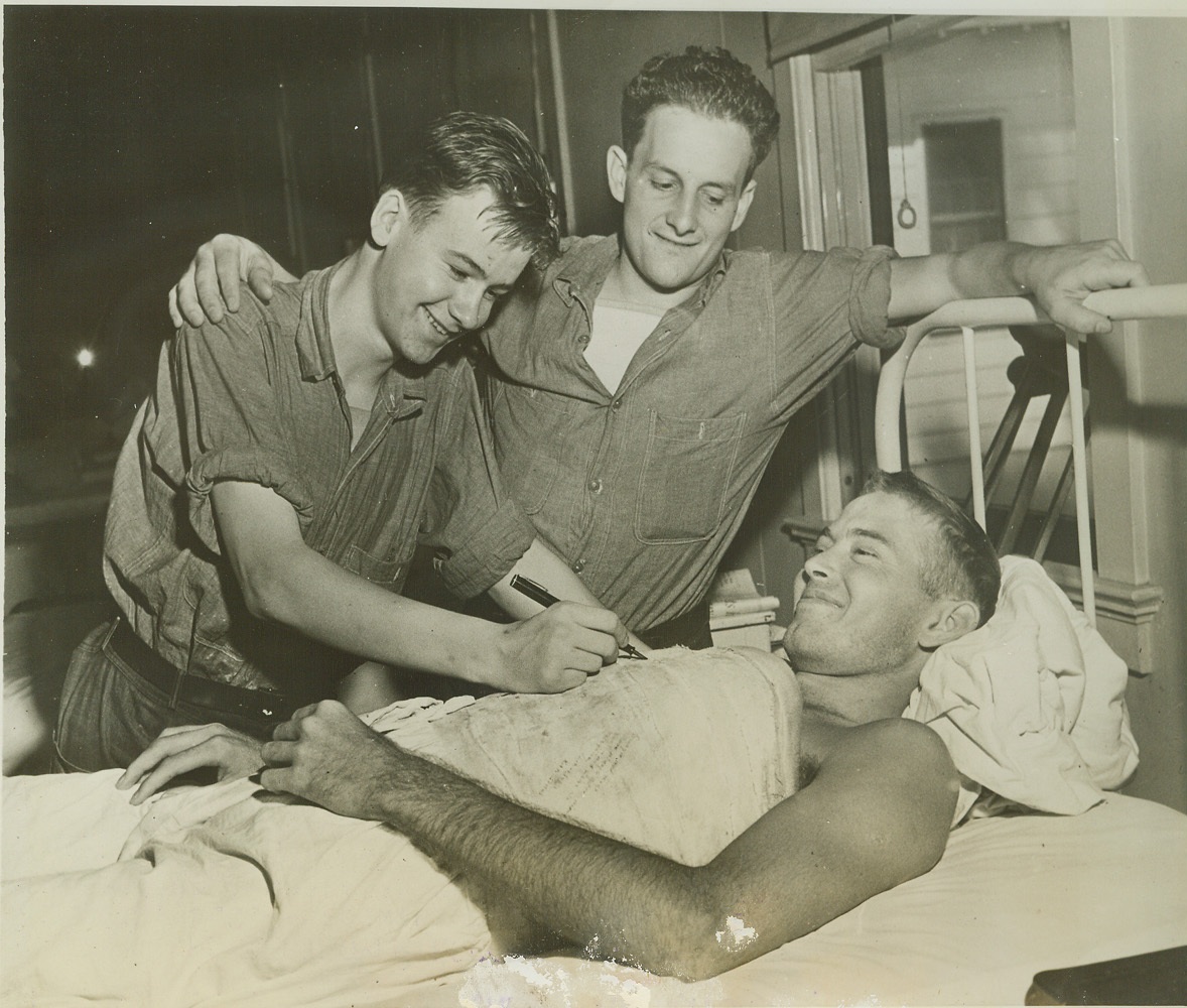 Survived Destroyer Escort Sinking, 7/15/1944. Charleston, S.C. -- Recently returned to the States aboard a hospital ship and now under-going treatment a the Naval Hospital in the Charleston Navy Yard for injured backs, these three sailors were among survivors of the sinking of the U.S. Destroyer Escort Fechteler in the Mediterranean during the month of May. Seaman 2/c Edward Laurence Andruss, Malden, Mass., adds his autograph to the many decorating the cast on Seaman 2/c ...vin Garvin Pritchett, Dallas, Tex., while Water Tender 2/c ...k John Galanic, ...ain, O., looks on. Credit (US Navy Photo from ACME);
