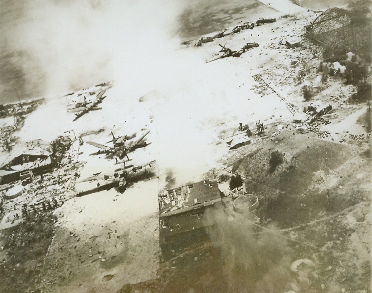 NIP SEAPLANTS ON THE FRISK, 7/8/1944. SAIPAN—The apron of this Jap seaplane base in upper Tanapog Harbor is littered with smashed planes caught by our carrier-based planes and naval bombardment during the invasion of Saipan. Hangars and repair huts have been wrecked. Although his airstrip is still in Jap hands-it is of small use to the enemy, for it has been almost totally wrecked.  Credit: ACME.;