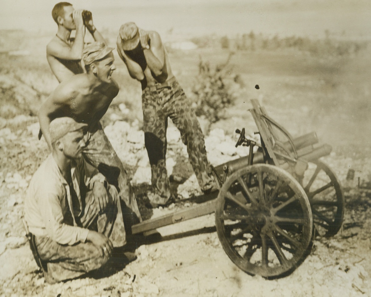 LET ‘ER RIP!, 7/7/1944. SAIPAIN, MARIANAS—The wallop packed by this Jap gun captured on Saipan is well evidenced here. Even the tough Leatherneck hides his face from the repercussion of its fire, as one of his buddies shouts “Let ‘er go,” as they turn the gun on its former owners during the fight for Garapan, key Jap city on Saipan.  Credit: OFFICIAL U.S. MARINE CORPS PHOTO FROM ACME.;