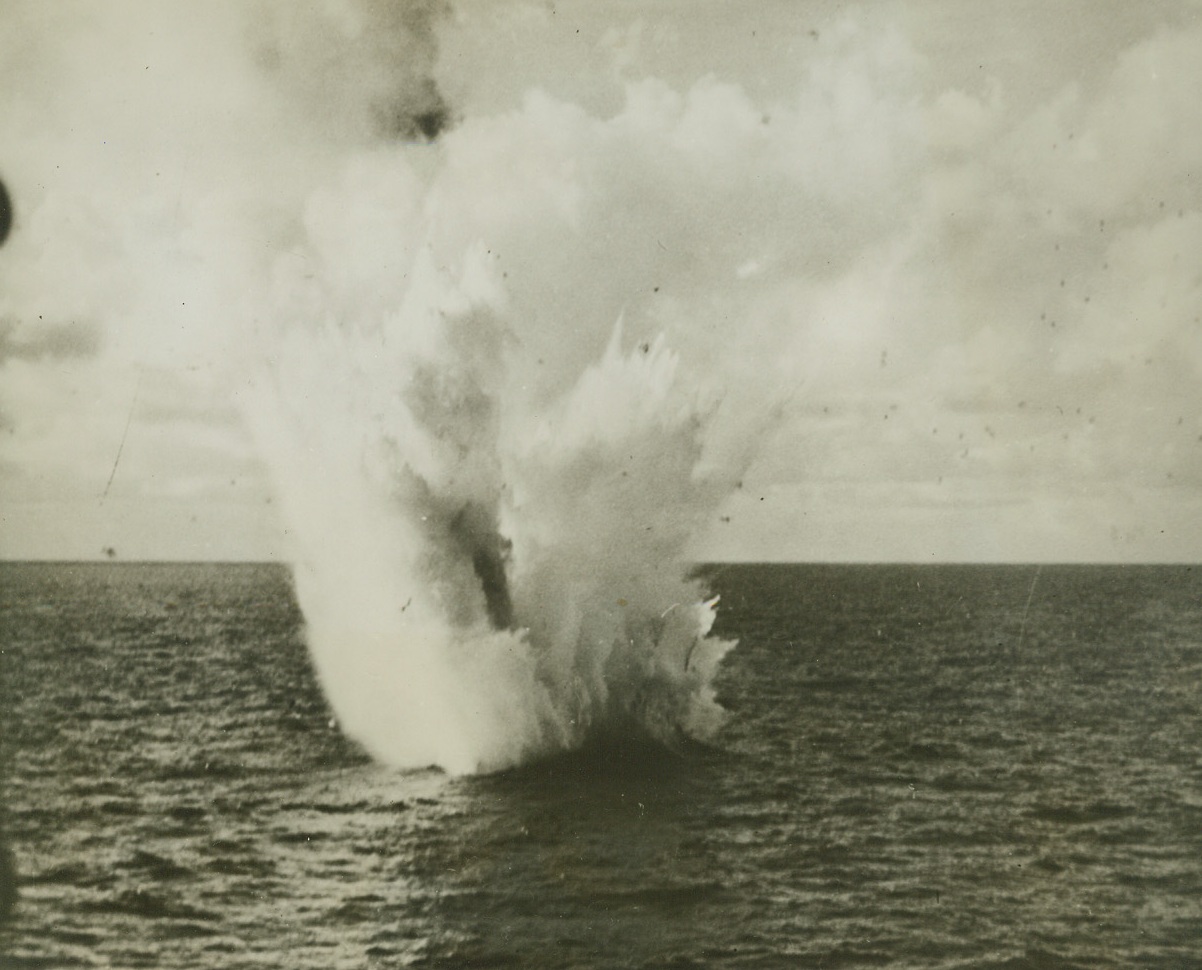 Into the Deep!, 7/24/1944. Testifying to the accuracy of U.S. Navy anti aircraft fire, this photo shows the fiery end of a Jap twin-engined plane shot down in the Pacific by an American flattop’s gunners.  A salty geyser marks the grave of the warbird. Credit line (Official U.S. Navy photo from ACME);