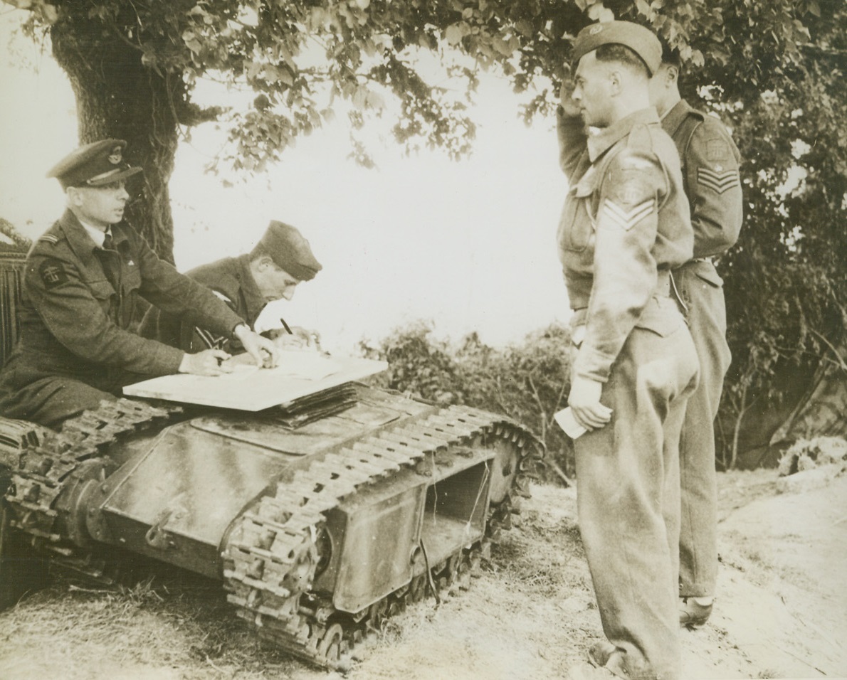 “Beetle” Tanks Serves Allies, 7/12/1944. France - - Using a knocked out German “beetle” tank as a desk, members of an R.A.F. beach squadron receive their first pay since their arrival in Normandy.  Cpl. R.W. Richards salutes his officer behind the German miniature tank tightly clutching three-weeks pay in his free hand.  Squadron arrived on June 6, and was so busy unloading ships that the unit requested pay be delayed since there was no time to spend it anyway. Credit (British official photo from ACME);