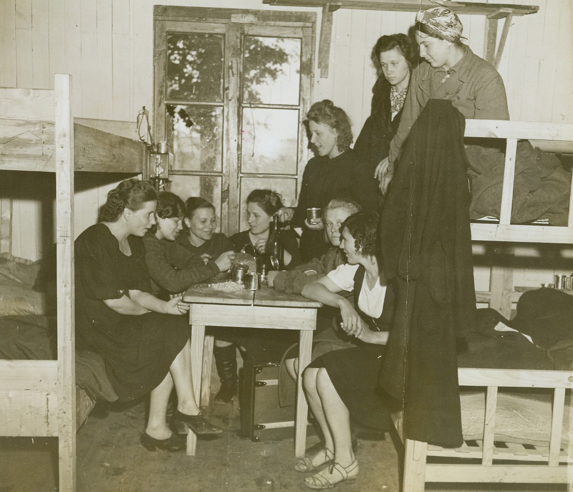 Gab Fest Among Women Refugees, 7/10/1944. Normandy, France—French refugees, driven from their homes by the course of the war in France, gather in a friendly group among their bunks in an evacuation camp and talk about the days that were and the happy days to come after the Germans have been driven from their homeland. Yesterday in a triumphant push, British and Canadian forces entered Caen, principal blockade on the road to Paris.  Credit: ACME photo by Andrew Lopez, War Pool Correspondent.;