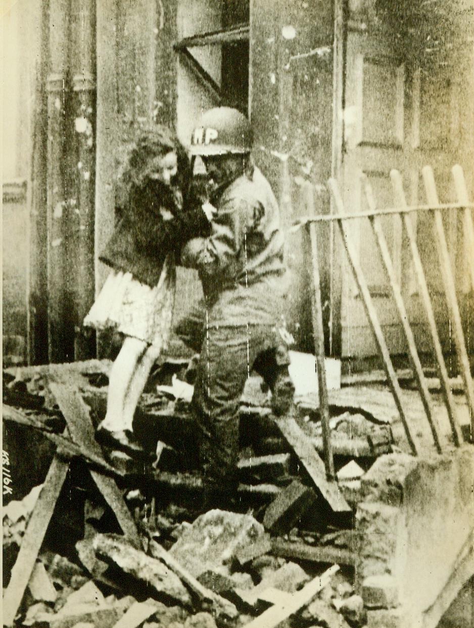 Yank Aids Flying Bomb Victim, 7/5/1944. ENGLAND - An American military policeman...lifts a young British girl out of her home which was hit by a Nazi flying bomb. Bombs, striking indiscriminately, have hit schools, hospitals and churches. Scene took place somewhere in England.;