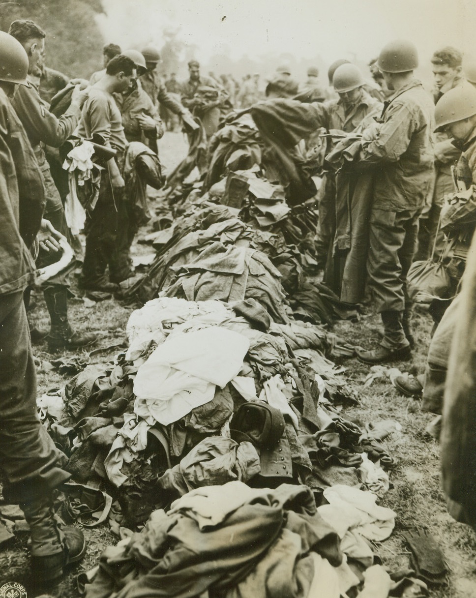 Excess Baggage, 7/26/1944. About to ship out as replacements to a combat unit, American soldiers rid their packs of clothes not needed at the battle front. Assigned to a combat unit, they must travel with the lightest possible gear. Credit: U.S. Army photo from ACME;