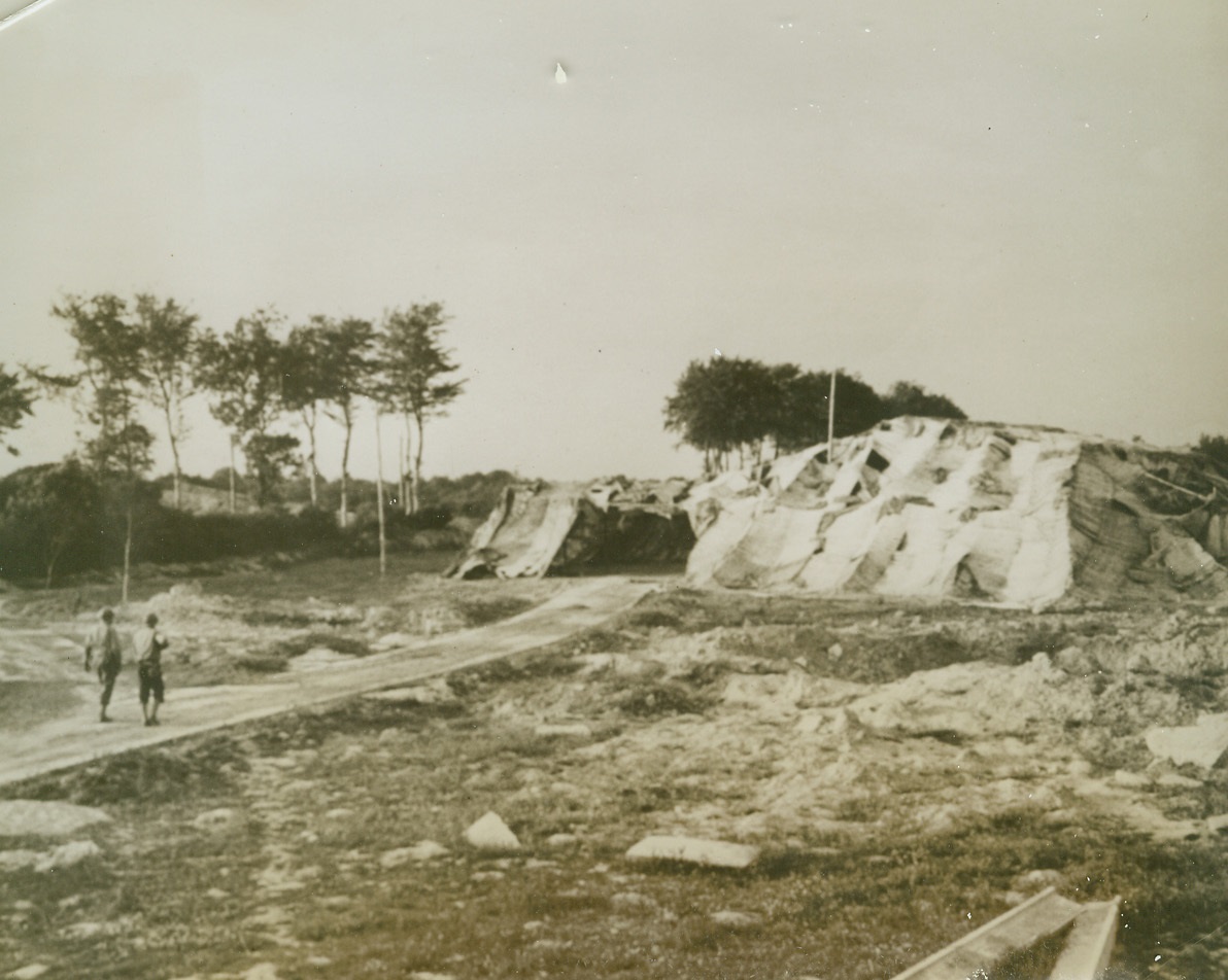 “Flying Bomb” Site Captured by Allies, 7/2/1944. Delassy, France – Chosen by the Nazis as a good spot from which to launch rocket bombs, this flying bomb site was captured by the Yanks during the Normandy assault. Two Yanks walk toward the heavily camouflaged control house in background. Credit: ACME;