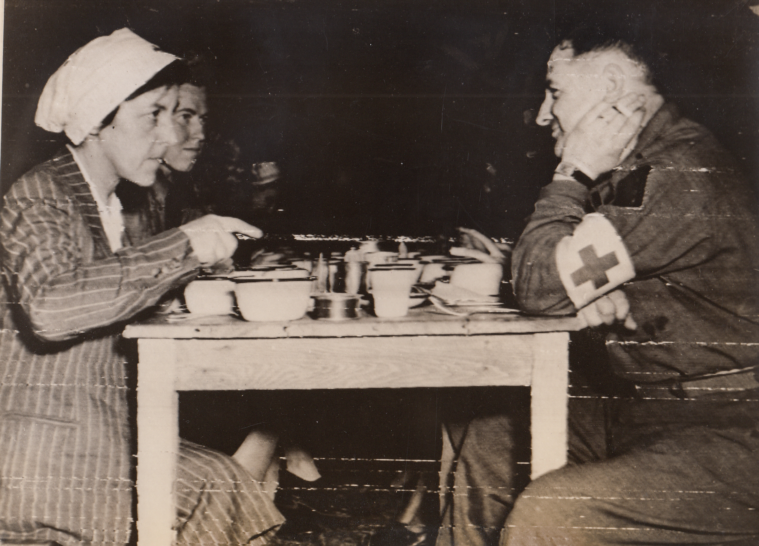 German Nurses Eat American Rations, 7/3/1944. Cherbourg, France – These German nurses, eating with the chaplain in the mess hall of an American hospital in Cherbourg, caused the war on the Cherbourg front to come to a temporary halt. Captured by our American forces, they were returned by ambulance to the German lines while all fire halted in a temporary medical truce. As soon as the ambulance returned to the American line, the big guns once again began their bombarding.;